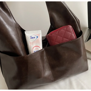 Vue détaillée du grand sac cabas rétro marron foncé en cuir souple avec poche frontale