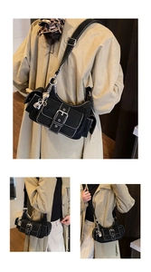Detail of black crescent hobo bag featuring white contrast stitching and heart charm