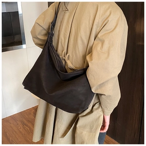 Detail of adjustable wide shoulder strap and metal buckle on black minimalist hobo bag