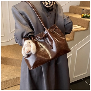 Détail d'un sac cabas marron foncé avec un charmant porte-clés lapin en peluche doux