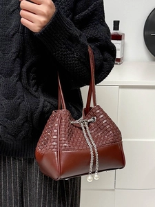 Brown woven PU leather bucket bag with chain strap and pearl charms on model