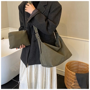 Detail of olive green suede tote bag showing contrast stitching and matching pouch bag