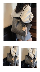 Macro detail of grey faux leather tote bag with white lettering and cute bear charm
