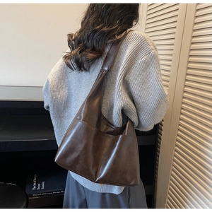 Détail du grand sac cabas marron foncé montrant les poches et le porté à l'épaule