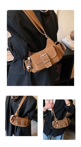 Detail of brown suede crescent bag with silver buckle and vintage motorcycle style