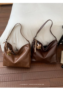 Détail d'un sac cabas vintage avec large bandoulière rivetée et charm ours mignon