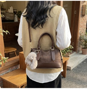 Detail of woven texture on brown Boston bag with plush bunny charm in a cafe setting