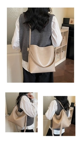 Detail view of the beige matte leather bucket bag showing the wide shoulder strap and capacity