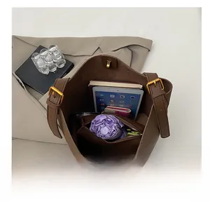 Interior view showing the large capacity of the brown lychee leather tote with daily essentials