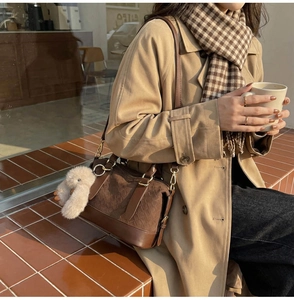 Close-up of retro brown pillow bag featuring woven texture and cute rabbit charm