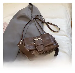 Detail of dark brown leather texture and silver buckle on a retro baguette shoulder bag