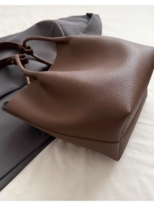 Detail of premium brown lychee pattern leather on a stylish bucket bag with handles