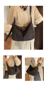 Detail of hobo bag featuring contrast white stitching on dark matte suede material