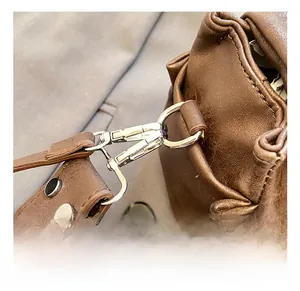 Detailed macro view of silver lobster clasp and D-ring on dark brown leather tote bag