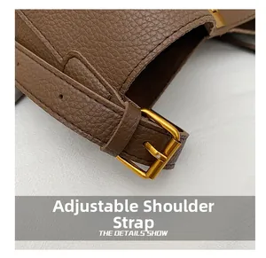 Detail of adjustable brown pebbled leather strap with polished golden buckle and buckle holes