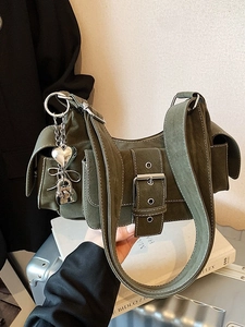 Army green suede shoulder bag with retro buckle and heart charms on a stylish suitcase