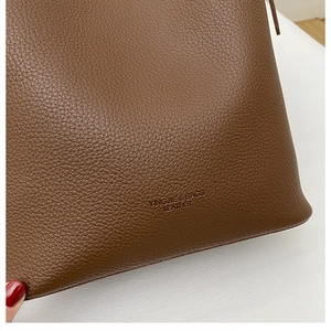 Close-up of brown lychee grain leather bag base with embossed brand logo and texture