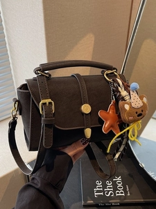 Retro dark brown matte leather handbag with adjustable strap and decorative charms