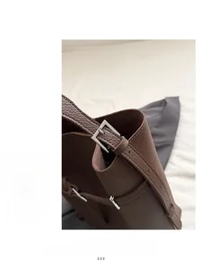 Detail of brown litchi pattern leather bucket bag with premium silver metal buckle hardware