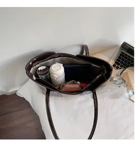 Detail view of large dark brown tote bag interior with multiple compartments and high capacity