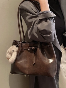 Sac fourre-tout rétro marron foncé en similicuir avec charm lapin porté par un mannequin