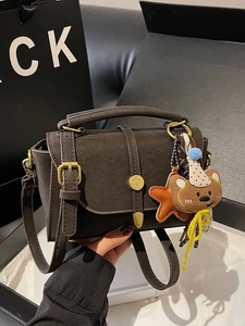 Deep brown matte leather handbag with vintage gold buckle and plush bear charm
