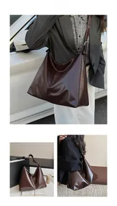Detail of soft chocolate glossy faux leather tote bag showing shiny surface and texture