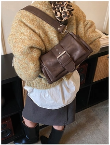 Detailansicht der dunkelbraunen Vintage-Umhängetasche mit großer Metallschnalle am Model