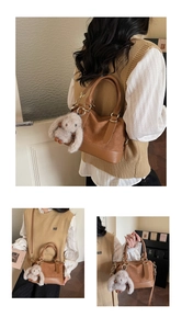 Detail of vintage brown handbag showing leather weaving, metal rings and bunny charm