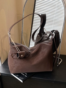 Large dark brown suede tote bag with minimalist shoulder strap and chic pendant accessory