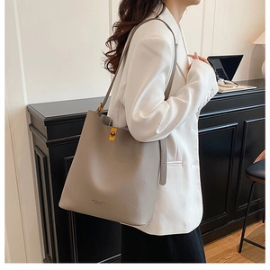 Close-up of grey pebble leather bucket bag with gold twist lock and brand logo