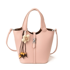 Rosafarbene Eimertasche mit Litschi-Struktur, Riemen und floralem Perlenanhänger