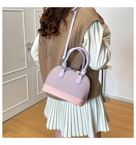 Detail of a textured shell-shaped handbag in lilac and pink with detachable shoulder strap