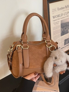 Caramel woven leather pillow bag with top handles, crossbody strap and plush bunny charm