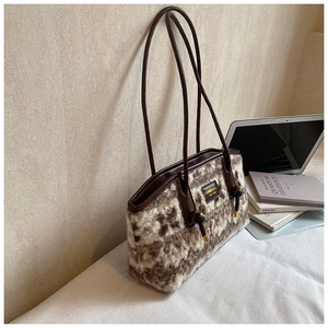 Detail of plush brown and white marble patterned tote bag with leather strap and logo