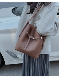 Close-up of brown lychee grain leather texture and silver buckle on bucket bag