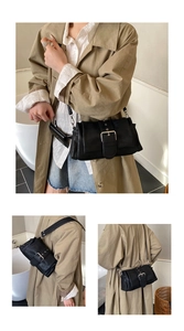 Detail view of black minimalist shoulder bag with silver buckle and detachable mini pouch
