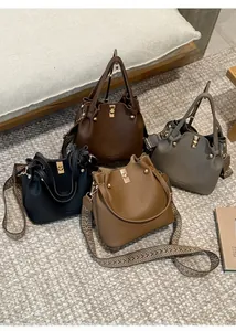 Detail view of four leather bucket bags in various colors with bohemian wide straps