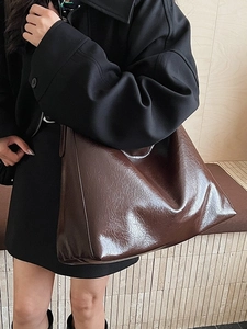 Minimalist large brown wrinkled patent leather tote bag in a stylish crossbody style