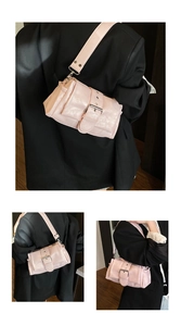 Detail of light pink faux leather shoulder bag with wide strap and buckle accent