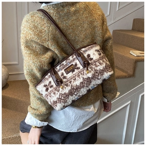 Detailed view of plush retro floral tote with brown leather strap and brand plaque