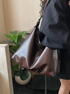 Fashionable dark brown hobo shoulder bag in glossy patent leather with wide strap