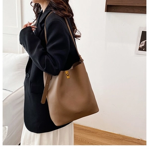 Detail of caramel leather shoulder bag with fine lychee grain and gold buckle