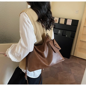 Detail view of the brown vintage tote bag with matching coin purse on a wooden floor