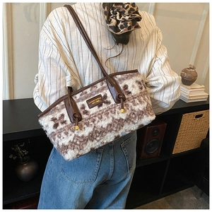 Detail of retro knit tote bag with geometric pattern and brown leather handle on model