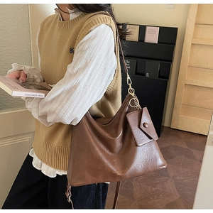Detailed macro view of vintage brown tote bag with matte texture and small envelope charm