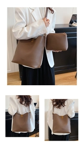 Detail of dark brown pebble leather bucket bag set with inner pouch and gold hardware