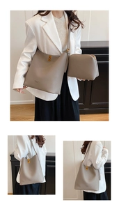 Detail view of the gray textured leather tote bag set with branded metal buckle closure