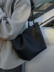 Minimalist black pebble leather tote bag for women showing a sleek commuter shoulder style