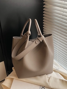 Elegant light brown lychee grain leather bucket bag with top handles and shoulder strap